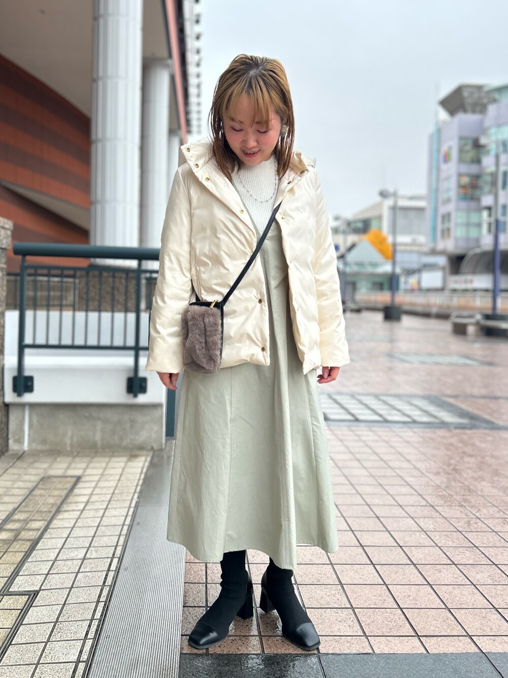 ホワイト系のダウンジャケット/コート、グレー系のワンピース、シルバー系のニット/セーターを着用したレディースの冬コーディネートの8枚目の写真