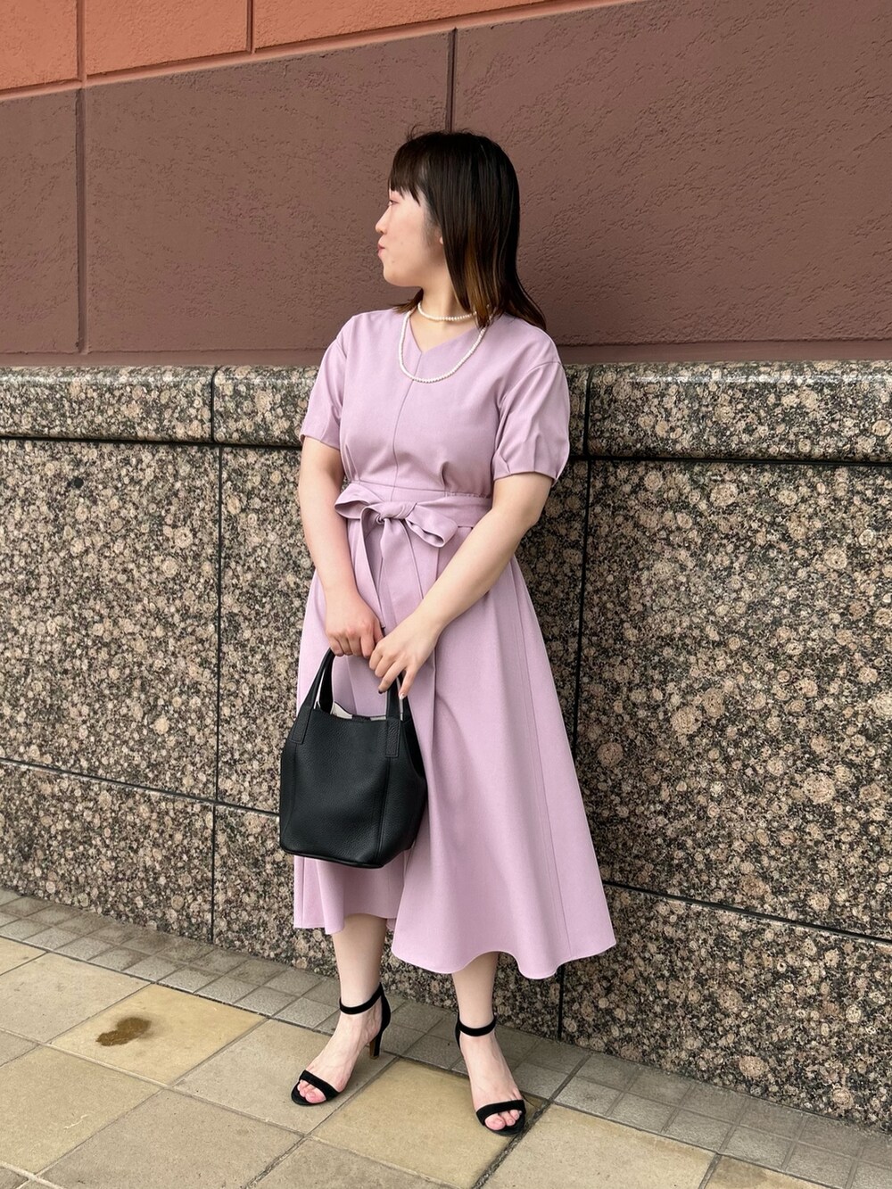 ピンク系のワンピース、ブラック系のトートバッグ、ホワイト系のネックレスを着用したレディースの夏コーディネートの6枚目の写真