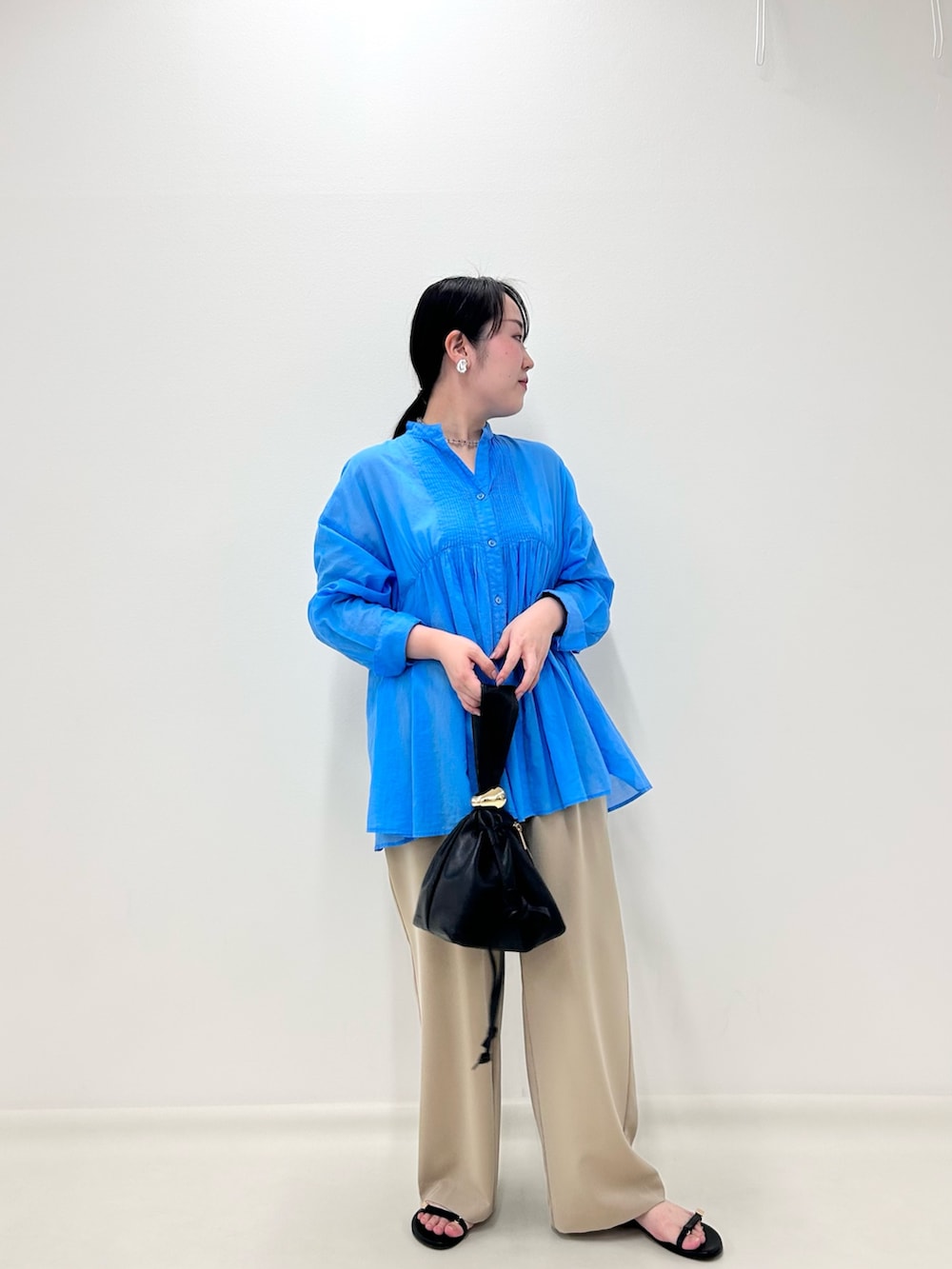 ブルー系のシャツ/ブラウス、ベージュ系のその他パンツ、ブラック系のショルダーバッグを着用したレディースの秋コーディネートの5枚目の写真