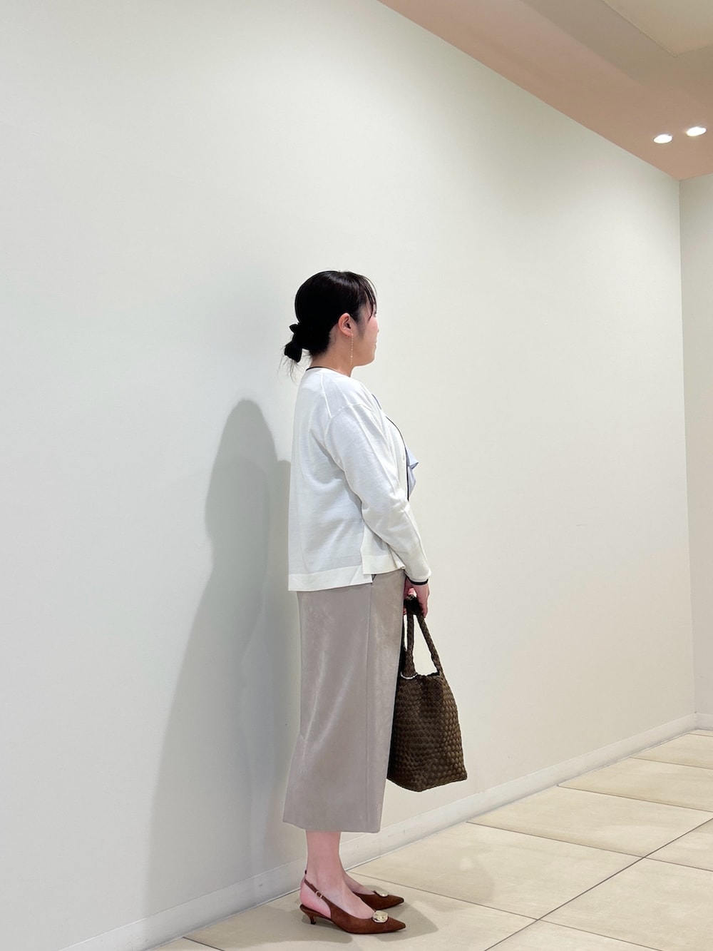 ホワイト系のカーディガン/ボレロ、ブルー系のシャツ/ブラウス、ベージュ系のスカートを着用したレディースの秋コーディネートの4枚目の写真