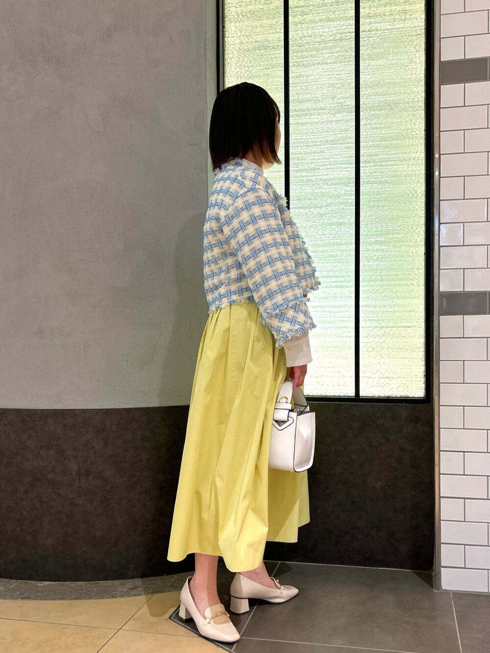 ブルー系のノーカラージャケット、ホワイト系のシャツ/ブラウス、ホワイト系のショルダーバッグを着用したレディースの冬コーディネートの3枚目の写真