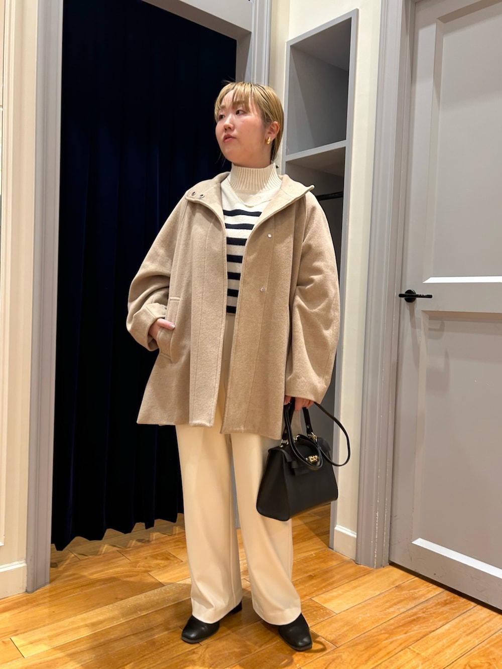 ベージュ系のその他アウター、ホワイト系のその他パンツ、ブルー系のニット/セーターを着用したレディースの冬コーディネートの9枚目の写真