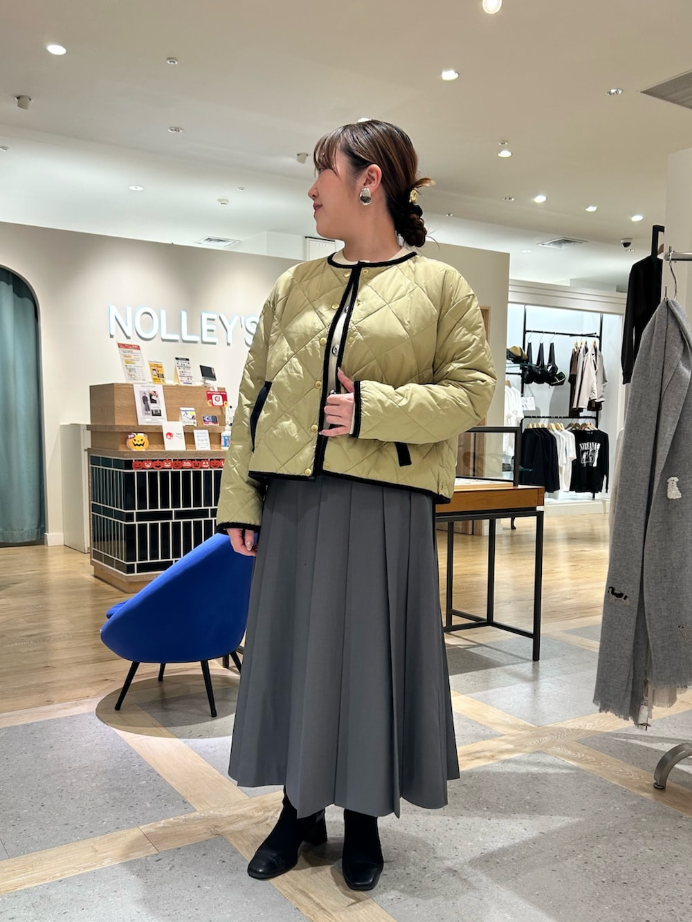 ベージュ系のダウンジャケット/コート、ホワイト系のカーディガン/ボレロ、グレー系のスカートを着用したレディースの秋コーディネートの5枚目の写真