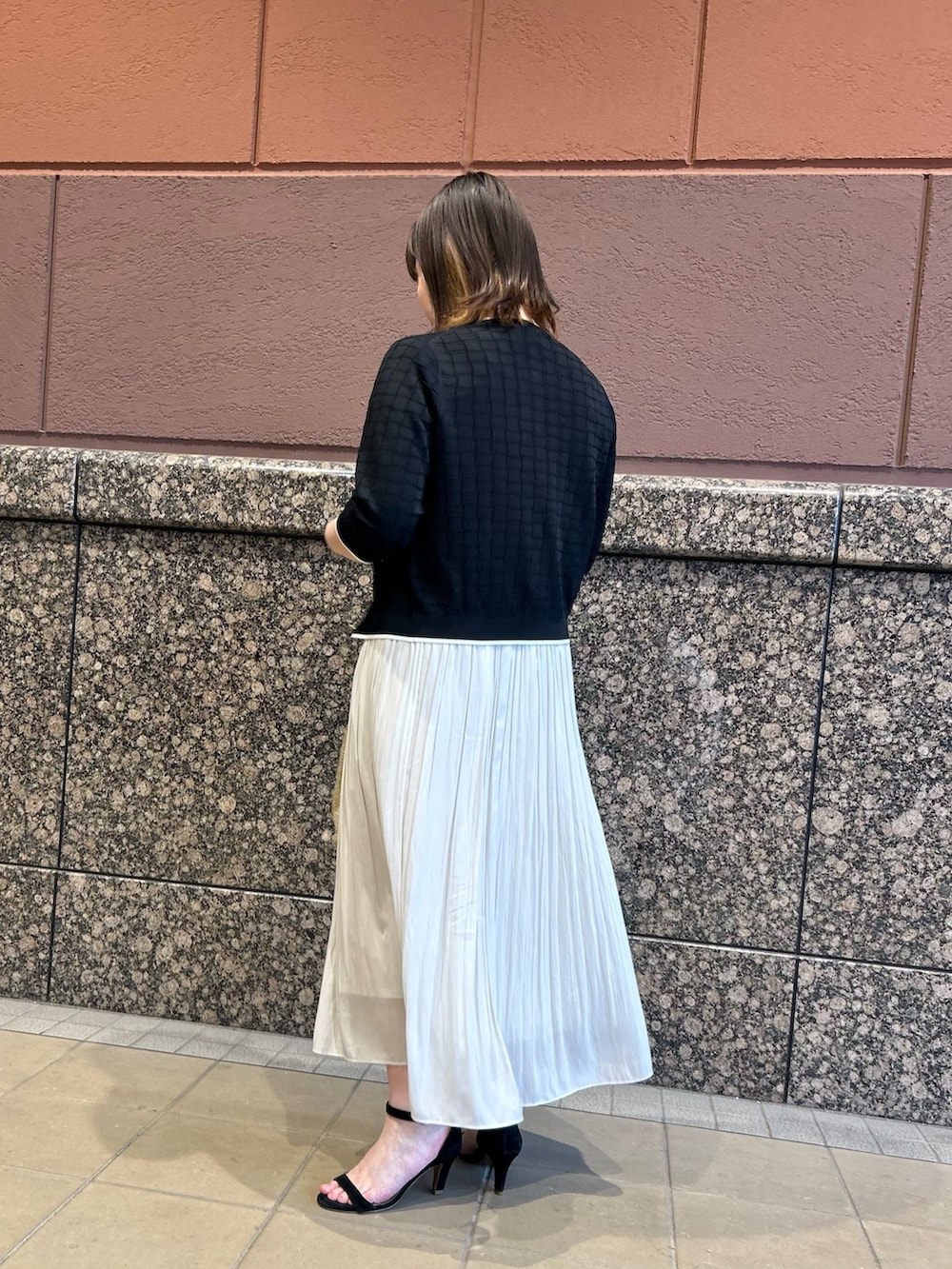 ブラック系のニット/セーター、ブラック系のカーディガン/ボレロ、ベージュ系のトートバッグを着用したレディースの春コーディネートの3枚目の写真