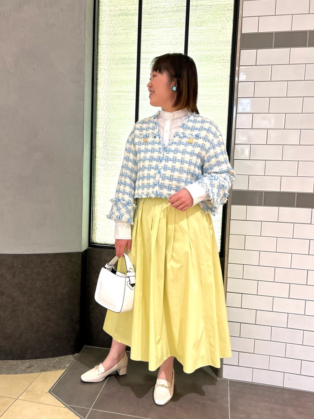 ブルー系のノーカラージャケット、ホワイト系のシャツ/ブラウス、ホワイト系のショルダーバッグを着用したレディースの冬コーディネートの7枚目の写真