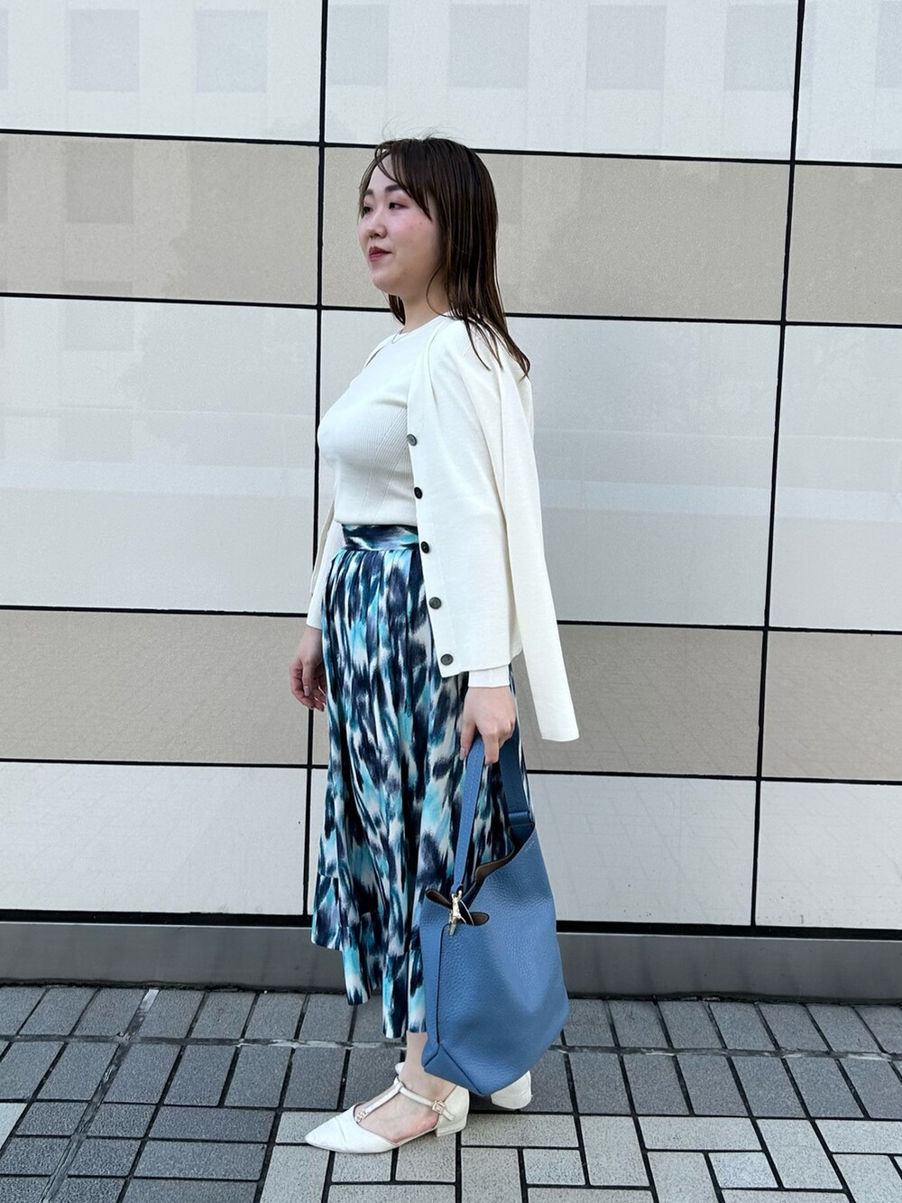 ホワイト系のカーディガン/ボレロ、ホワイト系のニット/セーター、ブルー系のスカートを着用したレディースの秋コーディネートの2枚目の写真