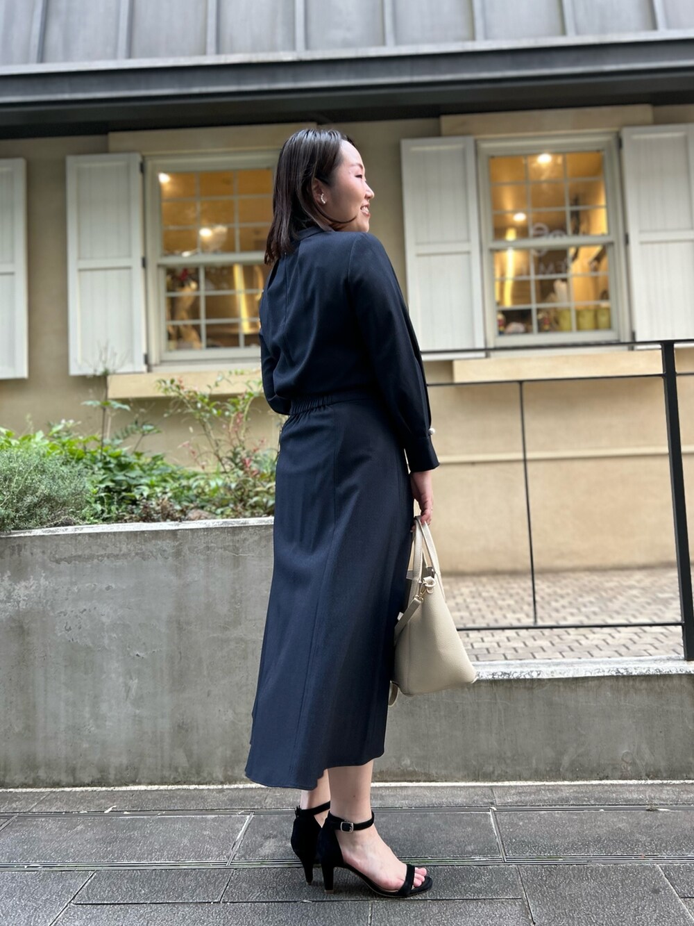 ブルー系のシャツ/ブラウス、ブルー系のスカート、ホワイト系のトートバッグを着用したレディースの秋コーディネートの7枚目の写真