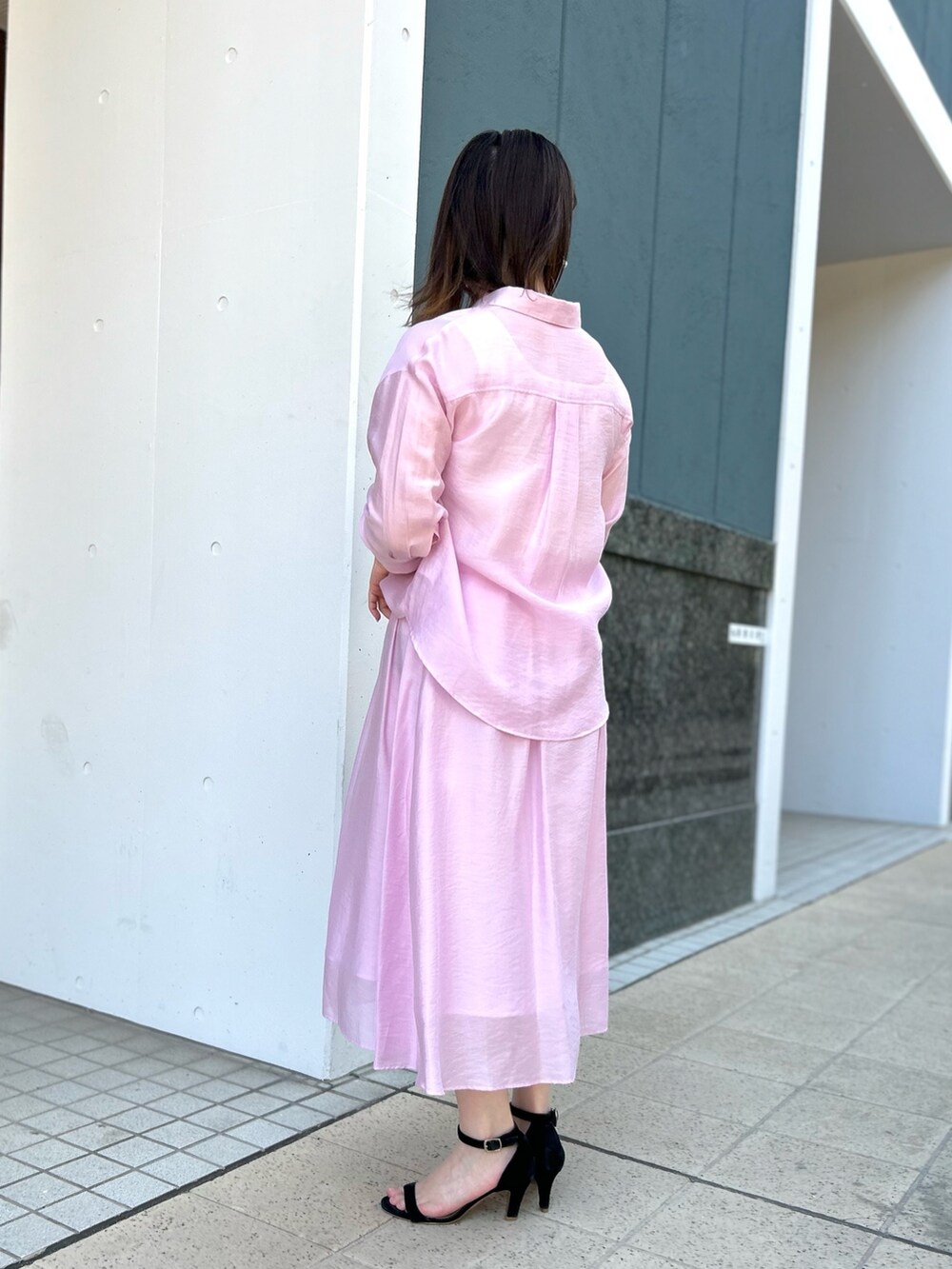 ピンク系のシャツ/ブラウス、ピンク系のスカート、ブラック系のショルダーバッグを着用したレディースの春コーディネートの5枚目の写真