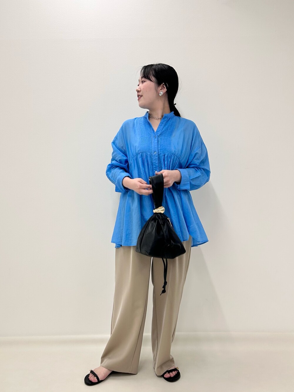 ブルー系のシャツ/ブラウス、ベージュ系のその他パンツ、ブラック系のショルダーバッグを着用したレディースの秋コーディネートの6枚目の写真