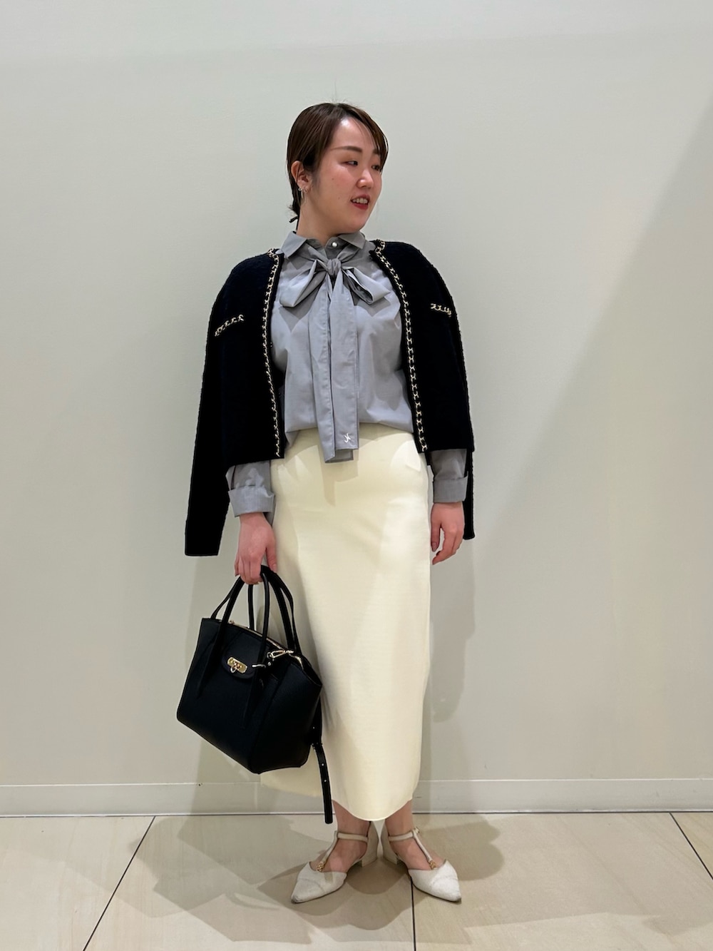 ブルー系のカーディガン/ボレロ、グレー系のシャツ/ブラウス、ホワイト系のスカートを着用したレディースの秋コーディネートの10枚目の写真