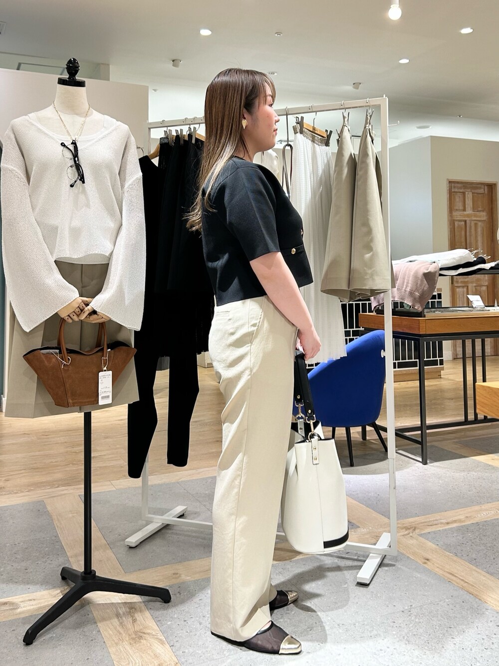 ブラック系のノーカラージャケット、ベージュ系のその他パンツ、ホワイト系のショルダーバッグを着用したレディースの夏コーディネートの4枚目の写真