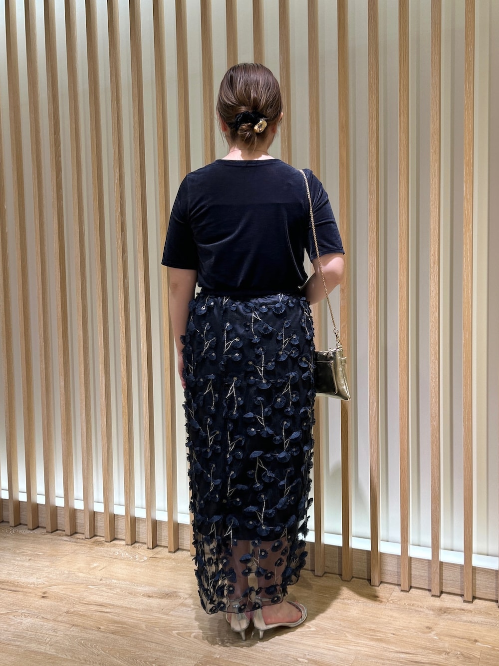 ブルー系のTシャツ/カットソー、ブルー系のスカート、ゴールド系のショルダーバッグを着用したレディースの秋コーディネートの3枚目の写真