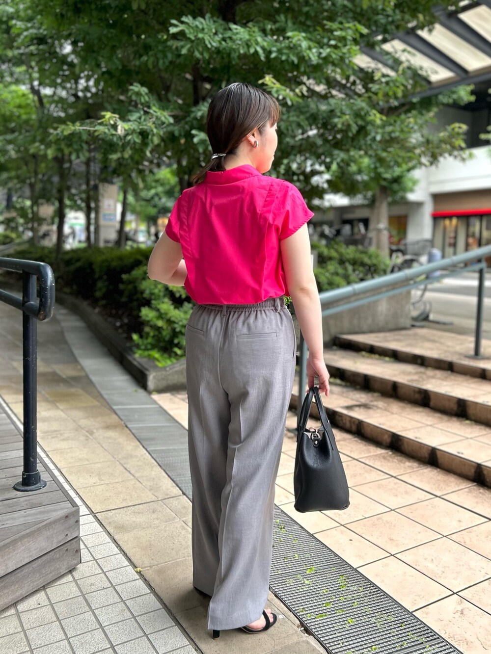 ピンク系のシャツ/ブラウス、ブラック系のトートバッグ、グレー系のその他パンツを着用したレディースの夏コーディネートの2枚目の写真
