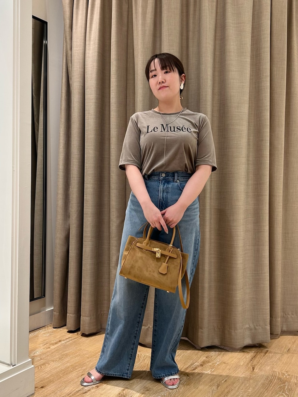 グリーン系のTシャツ/カットソー、ブルー系のデニムパンツ、イエロー系のトートバッグを着用したレディースの秋コーディネートの8枚目の写真