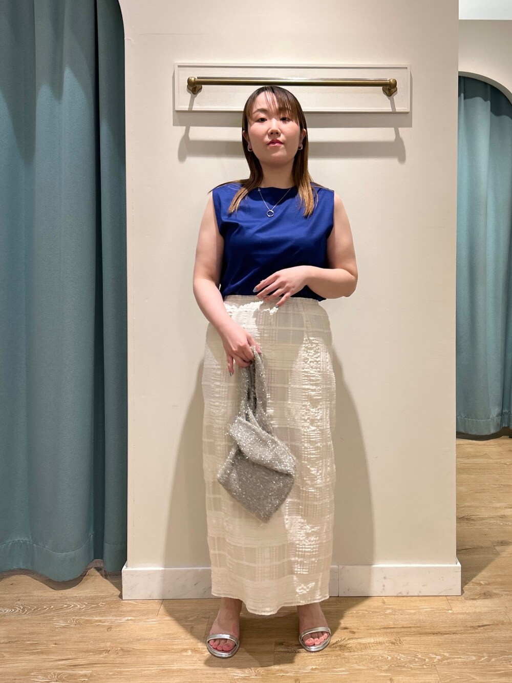 ブルー系のTシャツ/カットソー、ホワイト系のスカート、ベージュ系のバックパック/リュックを着用したレディースの夏コーディネートの6枚目の写真