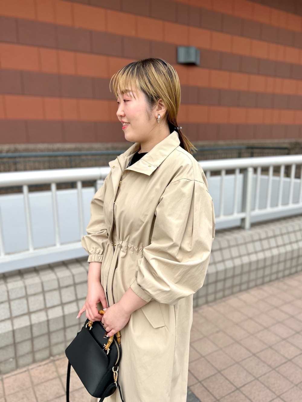 ベージュ系のその他アウター、ブラック系のニット/セーター、ピンク系のチノパンツを着用したレディースの春コーディネートの10枚目の写真