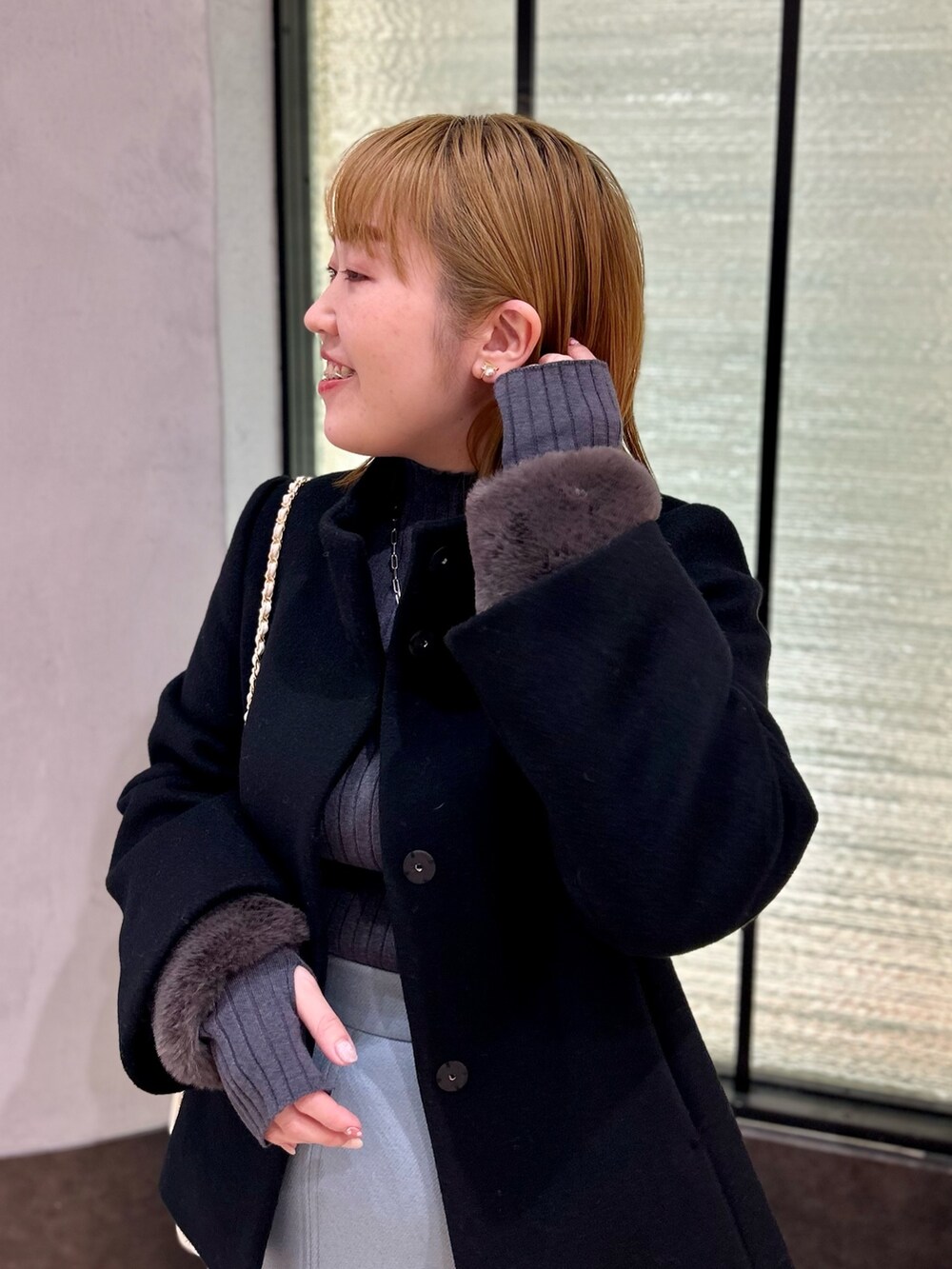 ブラック系のその他アウター、グレー系のニット/セーター、ブルー系のスカートを着用したレディースの冬コーディネートの10枚目の写真