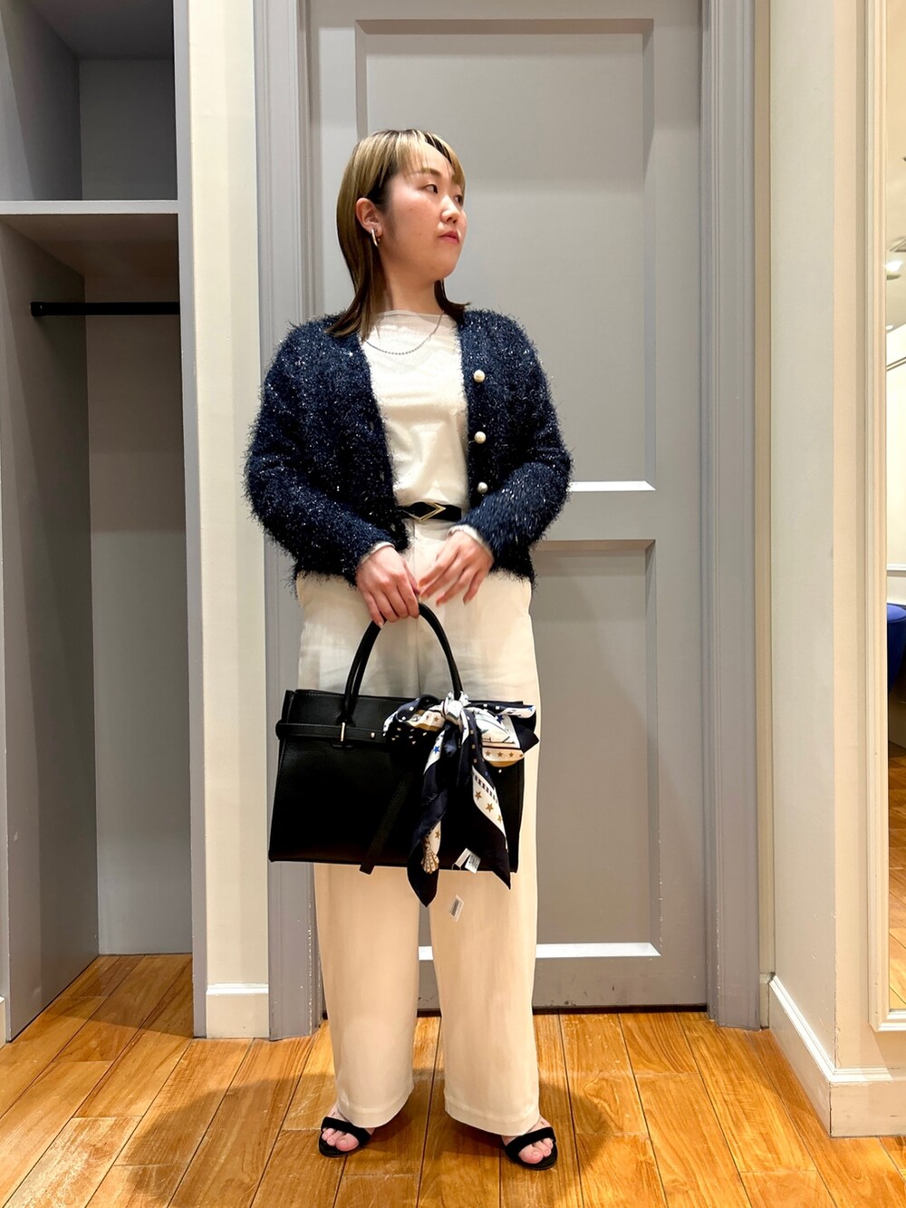 ブルー系のカーディガン/ボレロ、ホワイト系のチノパンツ、ベージュ系のTシャツ/カットソーを着用したレディースの春コーディネートの2枚目の写真