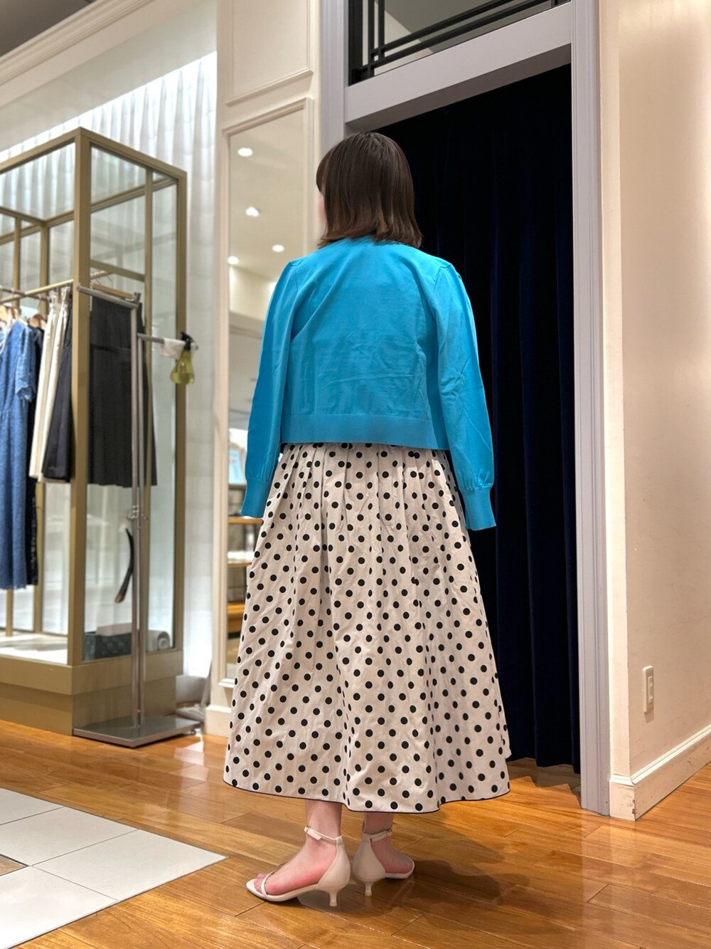 ブルー系のニット/セーター、ブルー系のカーディガン/ボレロ、ブラック系のスカートを着用したレディースの冬コーディネートの3枚目の写真