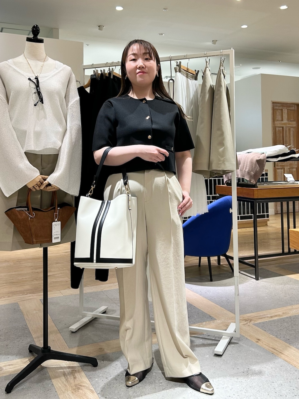 ブラック系のノーカラージャケット、ベージュ系のその他パンツ、ホワイト系のショルダーバッグを着用したレディースの夏コーディネートの5枚目の写真