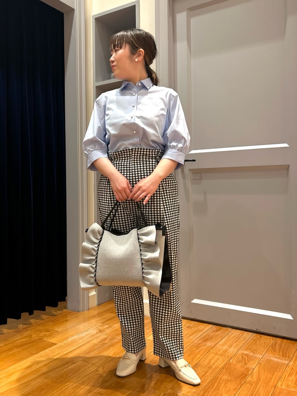 ブルー系のシャツ/ブラウス、ブラック系のその他パンツ、グレー系のトートバッグを着用したレディースの春コーディネートの2枚目の写真