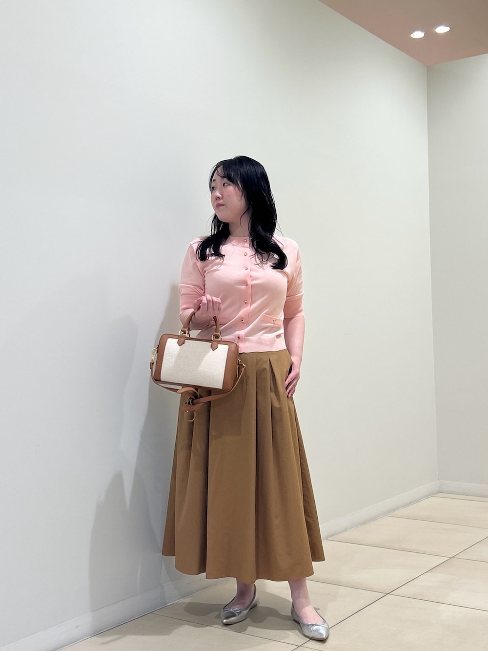 ピンク系のカーディガン/ボレロ、イエロー系のスカート、ブラウン系のボストンバッグを着用したレディースの夏コーディネートの7枚目の写真