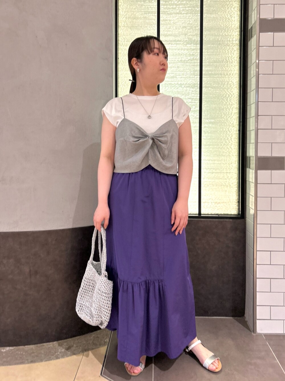 グレー系のTシャツ/カットソー、パープル系のスカート、シルバー系のバックパック/リュックを着用したレディースの夏コーディネートの10枚目の写真
