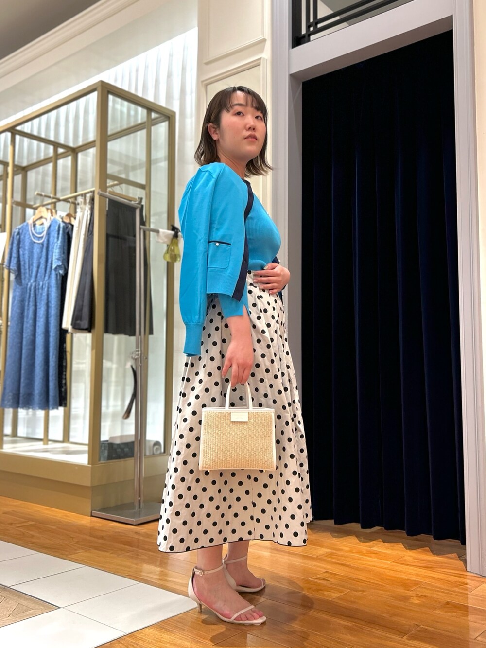 ブルー系のニット/セーター、ブルー系のカーディガン/ボレロ、ブラック系のスカートを着用したレディースの冬コーディネートの2枚目の写真