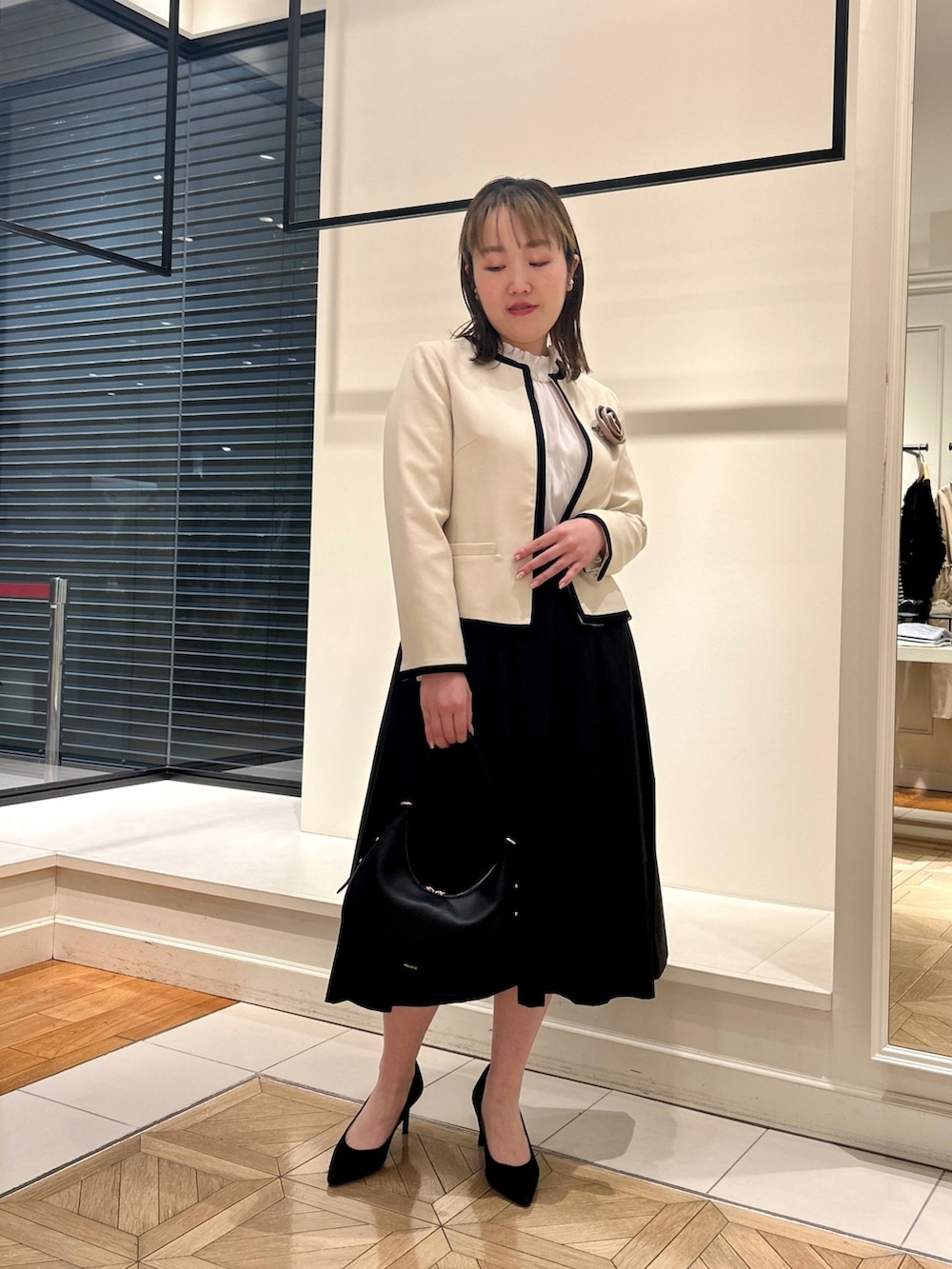 ホワイト系のノーカラージャケット、ホワイト系のシャツ/ブラウス、ブラック系のショルダーバッグを着用したレディースの冬コーディネートの10枚目の写真