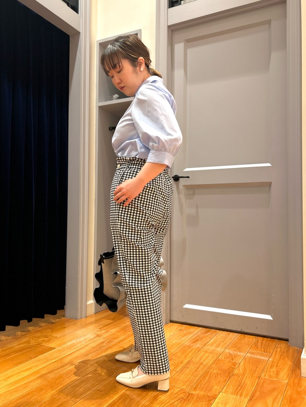 ブルー系のシャツ/ブラウス、ブラック系のその他パンツ、グレー系のトートバッグを着用したレディースの春コーディネートの3枚目の写真