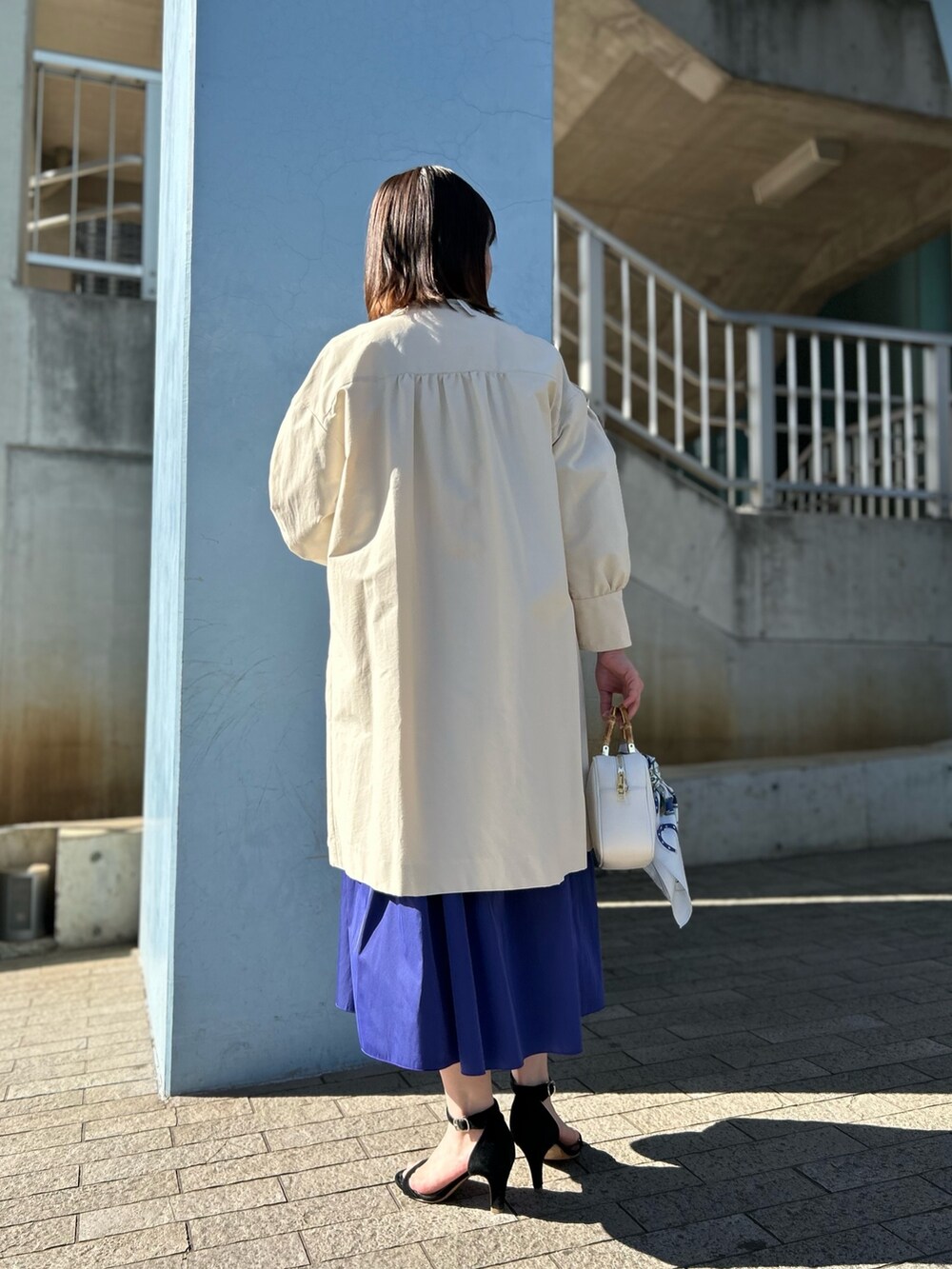 ホワイト系のその他アウター、グリーン系のTシャツ/カットソー、ブルー系のスカートを着用したレディースの冬コーディネートの5枚目の写真