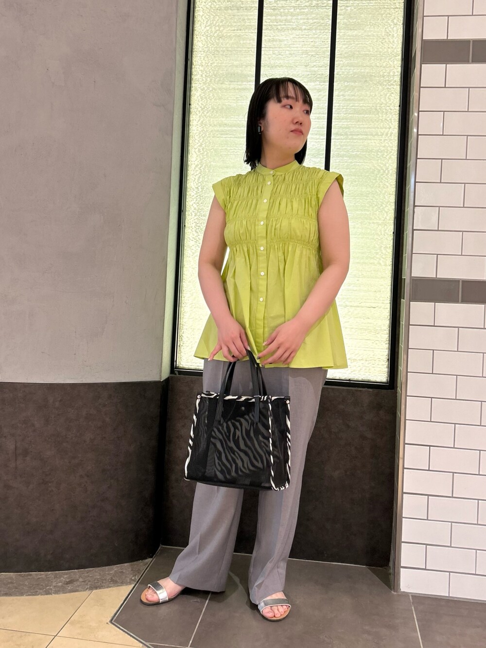 グリーン系のシャツ/ブラウス、ブラック系のトートバッグ、グレー系のその他パンツを着用したレディースの夏コーディネートの2枚目の写真