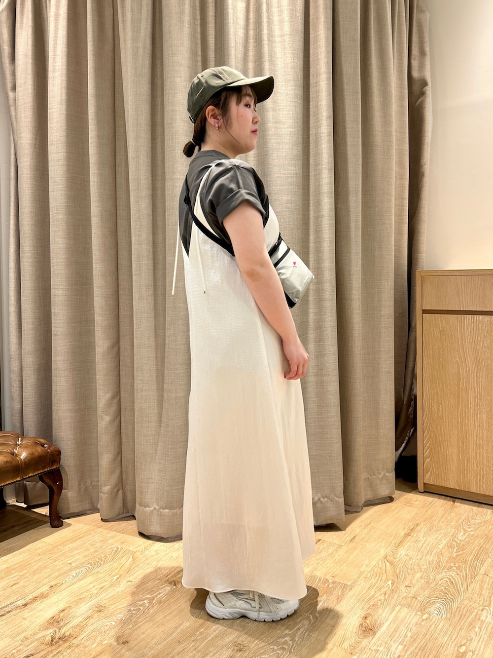 グレー系のTシャツ/カットソー、ホワイト系のワンピース、ベージュ系のショルダーバッグを着用したレディースの春コーディネートの3枚目の写真
