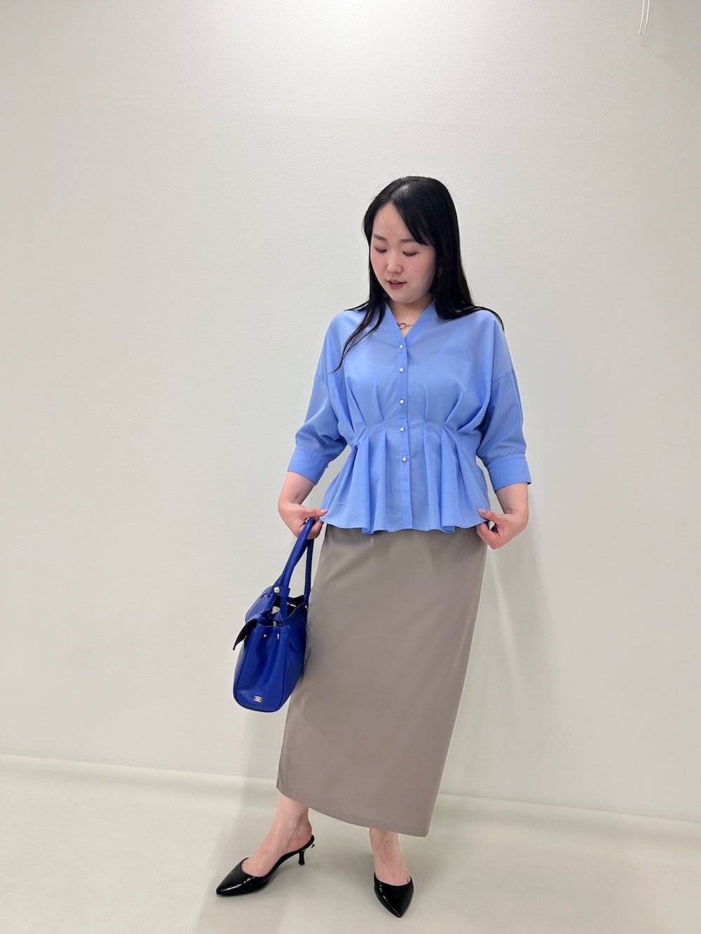 ベージュ系のスカート、ブルー系のシャツ/ブラウスを着用したレディースの夏コーディネートの6枚目の写真