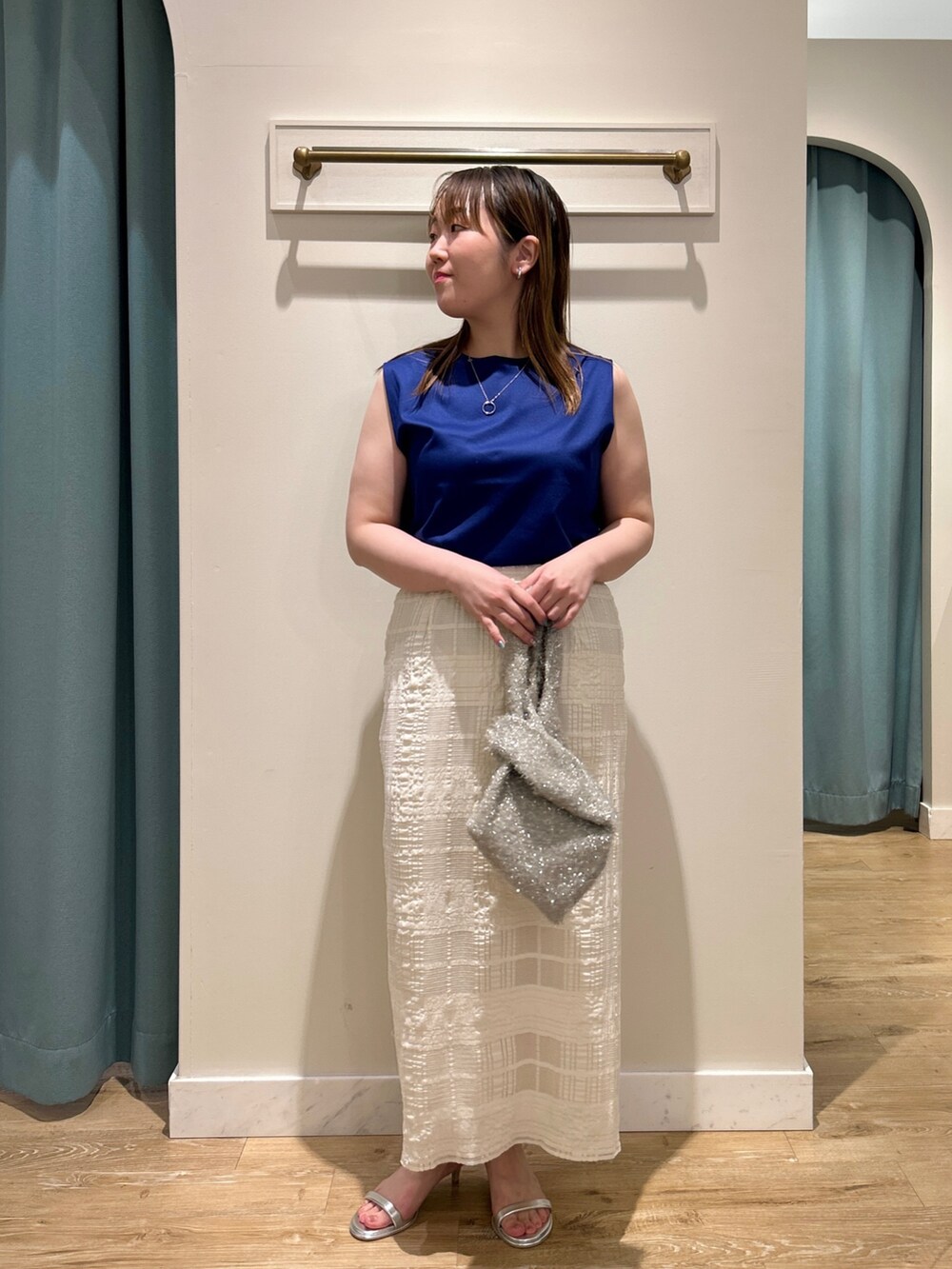 ブルー系のTシャツ/カットソー、ホワイト系のスカート、ベージュ系のバックパック/リュックを着用したレディースの夏コーディネートの7枚目の写真