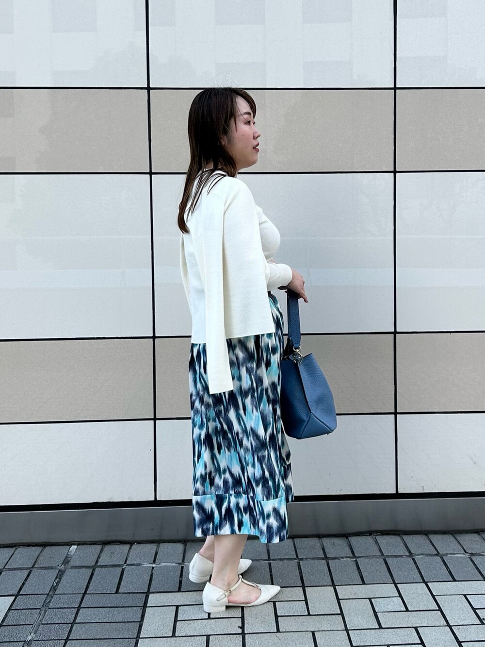 ホワイト系のカーディガン/ボレロ、ホワイト系のニット/セーター、ブルー系のスカートを着用したレディースの秋コーディネートの4枚目の写真