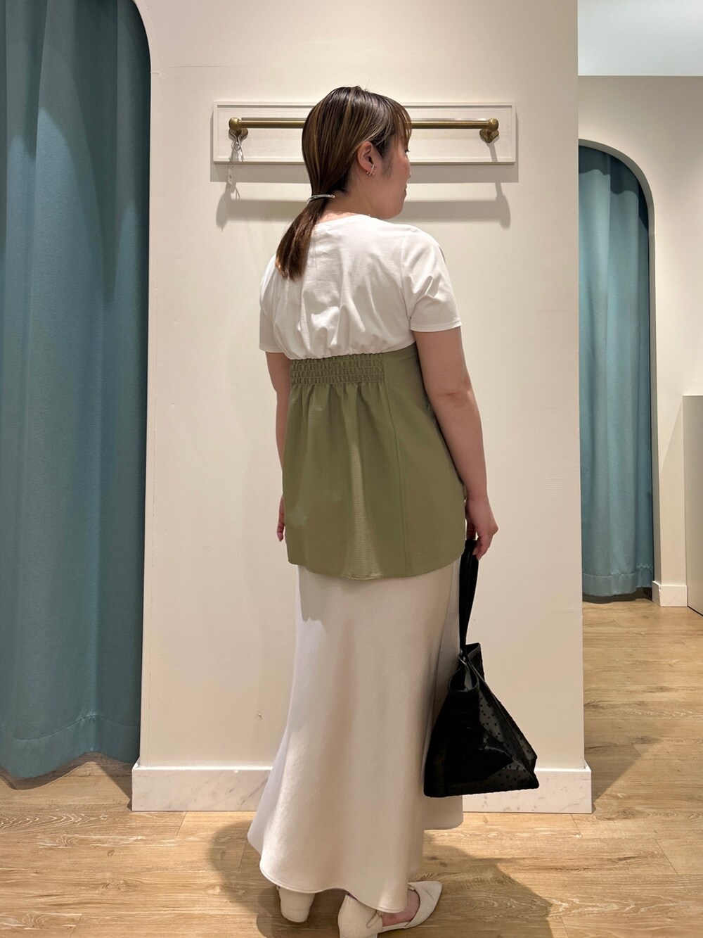 グリーン系のTシャツ/カットソー、ホワイト系のスカート、ブラック系のトートバッグを着用したレディースの夏コーディネートの9枚目の写真