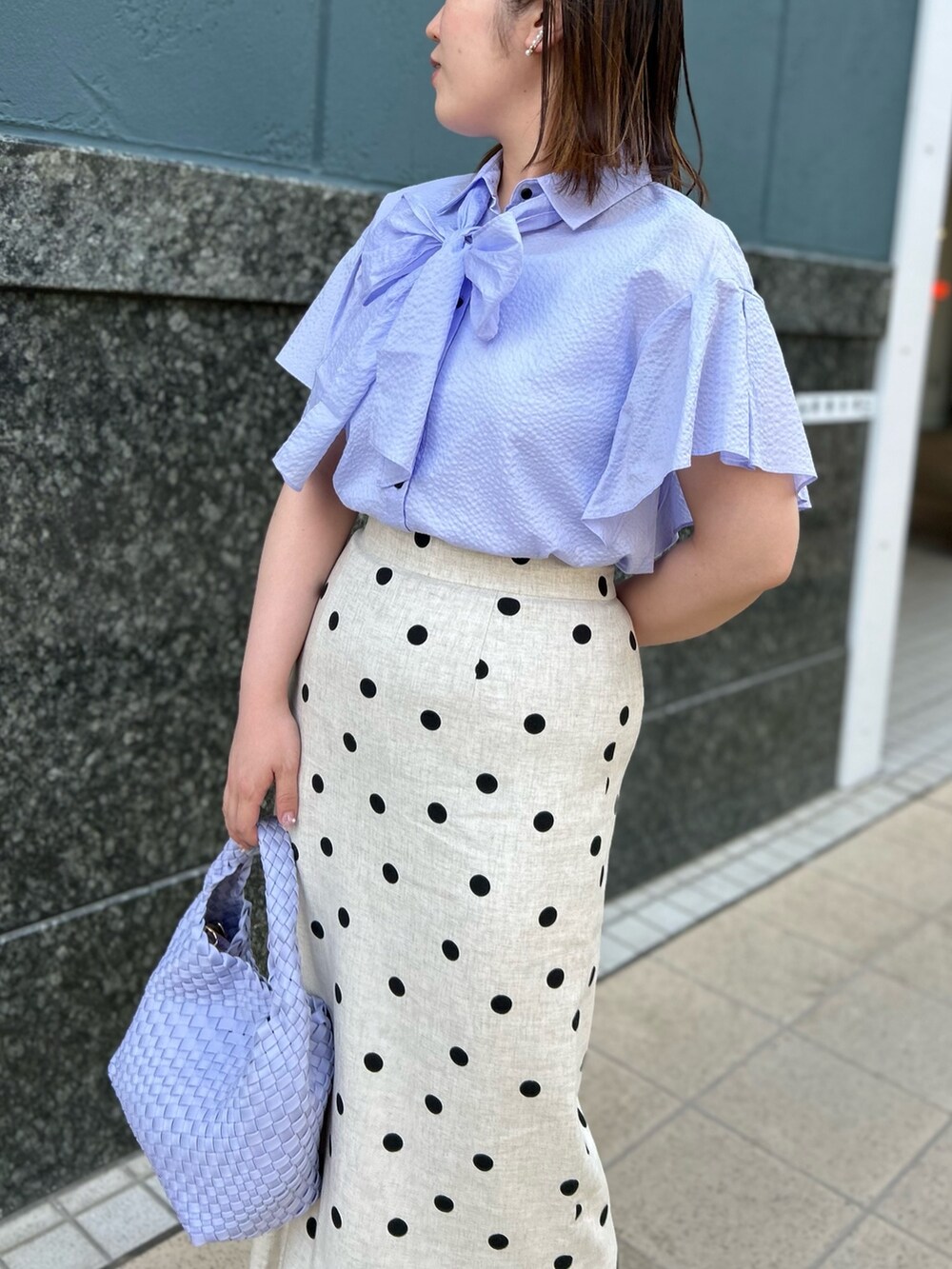 パープル系のシャツ/ブラウス、ベージュ系のスカート、パープル系のショルダーバッグを着用したレディースの春コーディネートの7枚目の写真