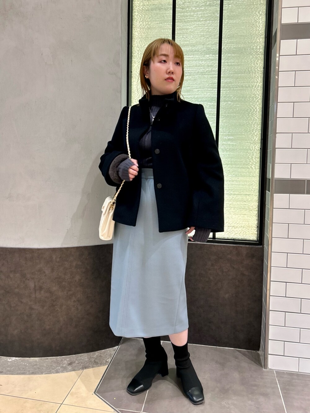 ブラック系のその他アウター、グレー系のニット/セーター、ブルー系のスカートを着用したレディースの冬コーディネートの6枚目の写真