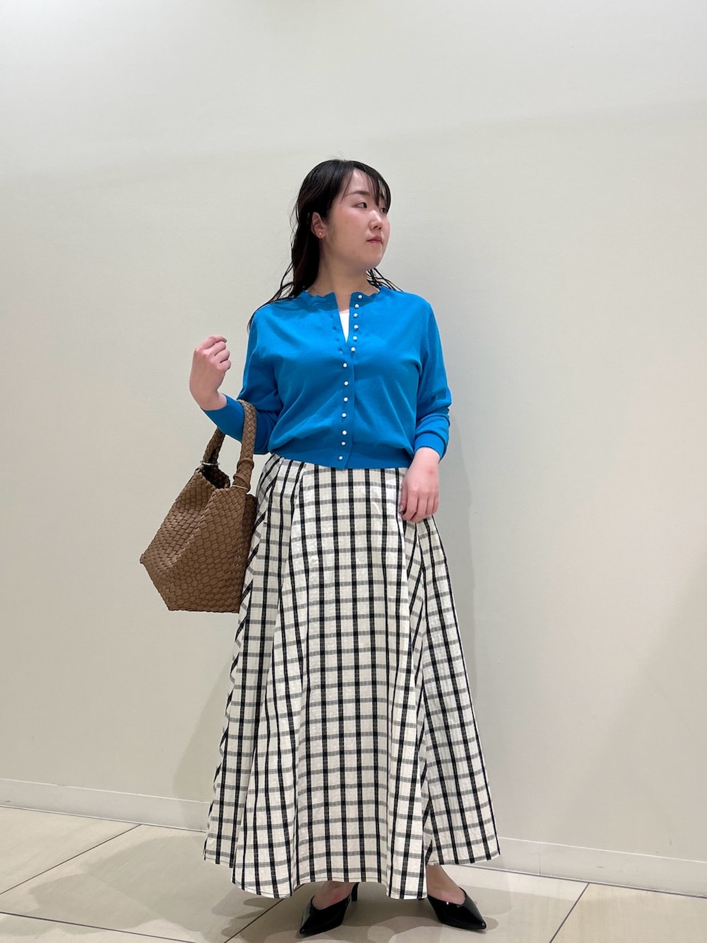 ブルー系のカーディガン/ボレロ、ホワイト系のスカート、ブラウン系のショルダーバッグを着用したレディースの春コーディネートの9枚目の写真