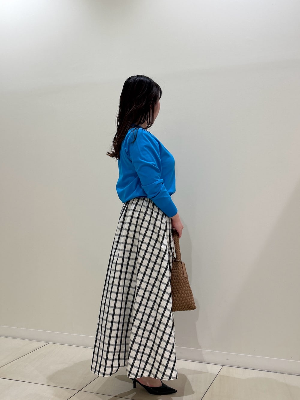 ブルー系のカーディガン/ボレロ、ホワイト系のスカート、ブラウン系のショルダーバッグを着用したレディースの春コーディネートの4枚目の写真