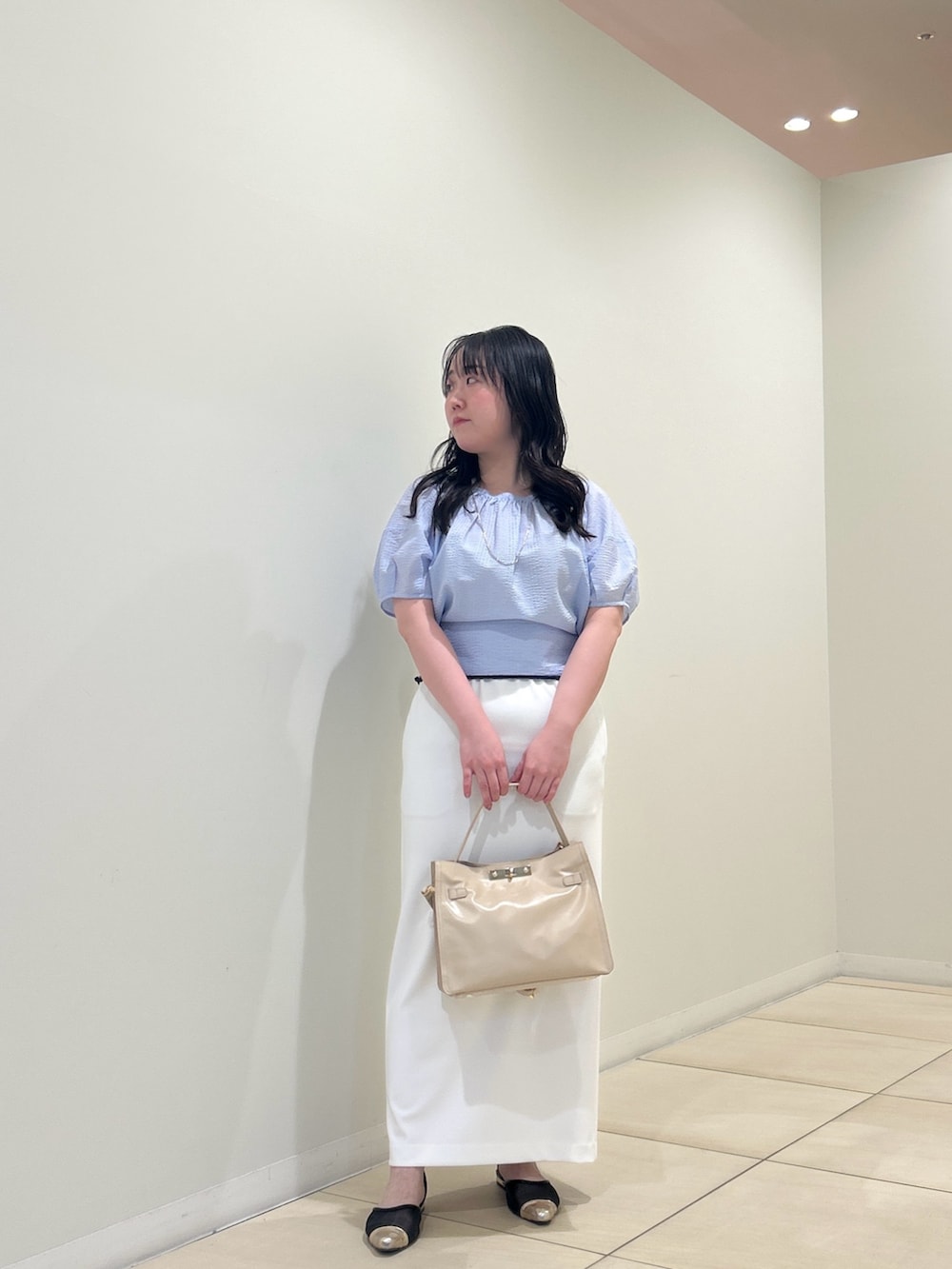 ブルー系のシャツ/ブラウス、ホワイト系のスカート、ベージュ系のトートバッグを着用したレディースの夏コーディネートの9枚目の写真