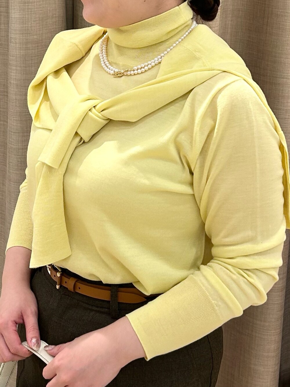 イエロー系のニット/セーター、イエロー系のカーディガン/ボレロ、ブラウン系のその他パンツを着用したレディースの秋コーディネートの7枚目の写真