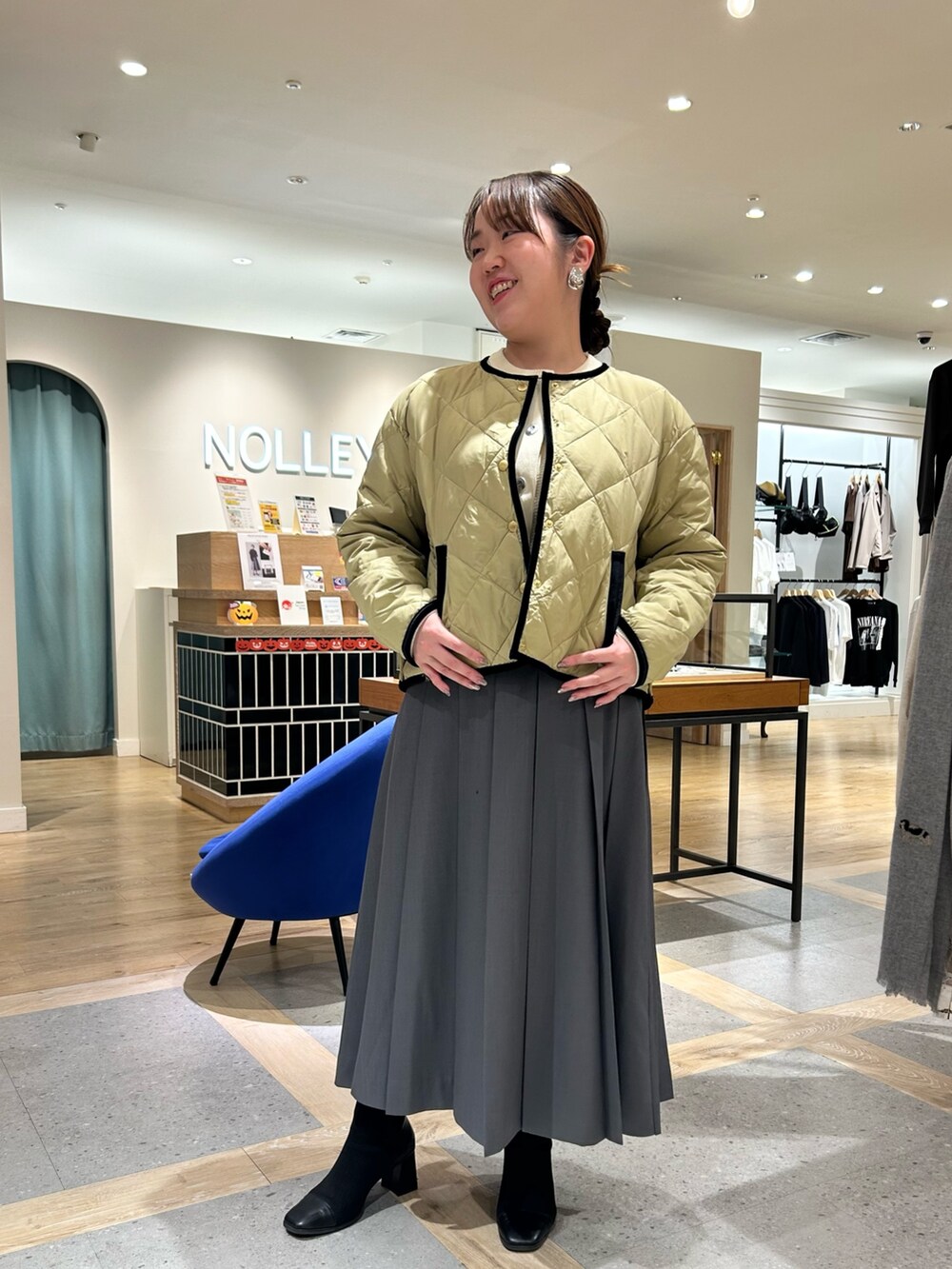 ベージュ系のダウンジャケット/コート、ホワイト系のカーディガン/ボレロ、グレー系のスカートを着用したレディースの秋コーディネートの6枚目の写真