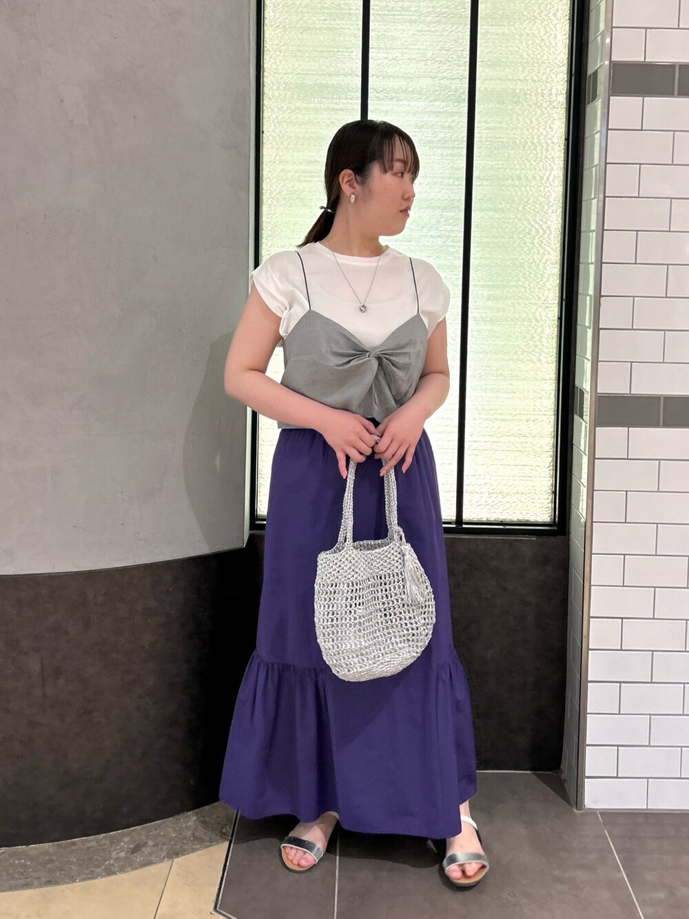 グレー系のTシャツ/カットソー、パープル系のスカート、シルバー系のバックパック/リュックを着用したレディースの夏コーディネートの4枚目の写真