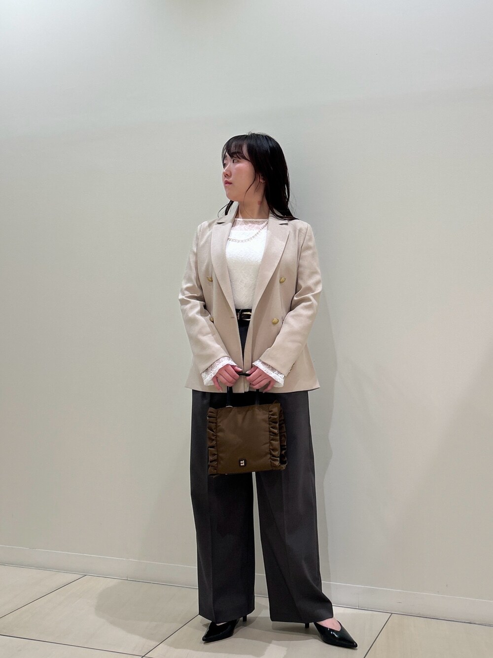ベージュ系のテーラードジャケット、グレー系のその他パンツ、ホワイト系のTシャツ/カットソーを着用したレディースの春コーディネートの6枚目の写真