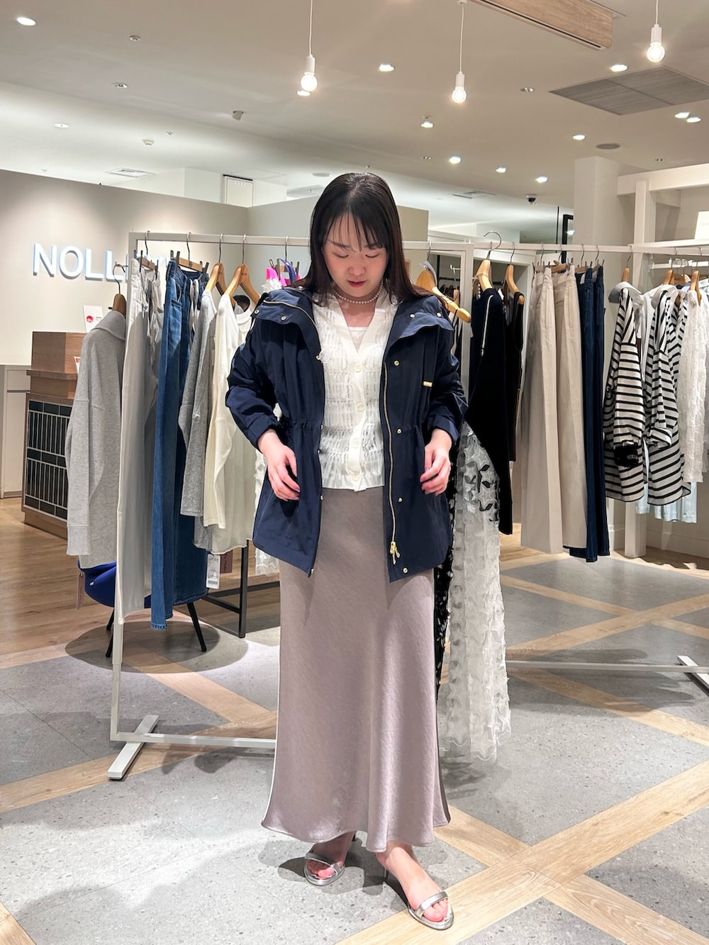 ホワイト系のカーディガン/ボレロ、グリーン系のスカート、ブルー系のブルゾンを着用したレディースの春コーディネートの6枚目の写真