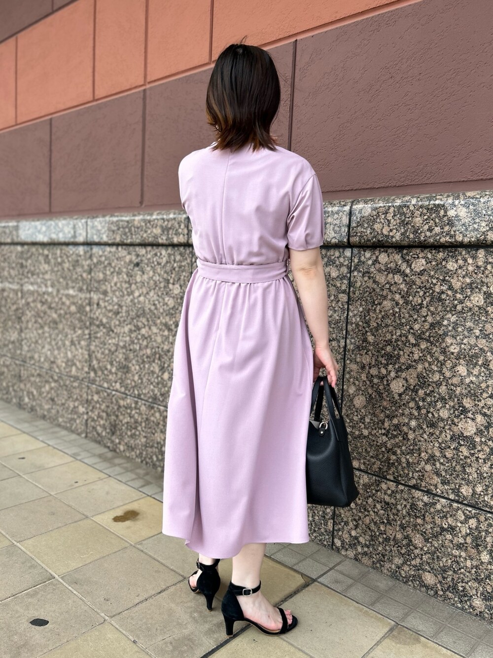 ピンク系のワンピース、ブラック系のトートバッグ、ホワイト系のネックレスを着用したレディースの夏コーディネートの5枚目の写真