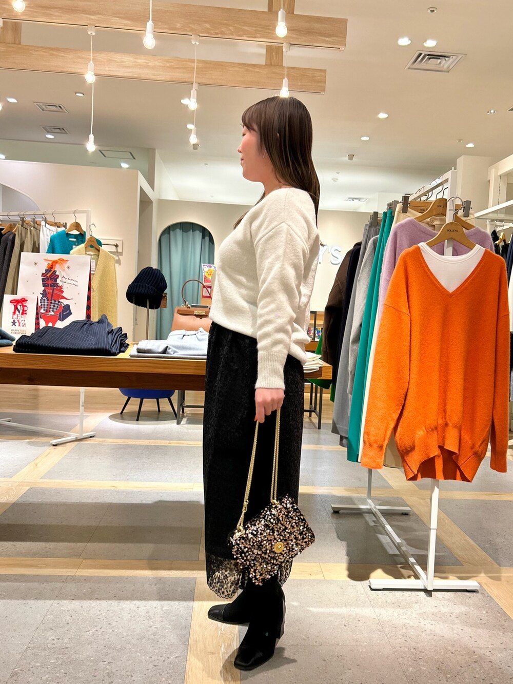 ホワイト系のニット/セーター、ブラック系のスカート、その他のショルダーバッグを着用したレディースの冬コーディネートの4枚目の写真