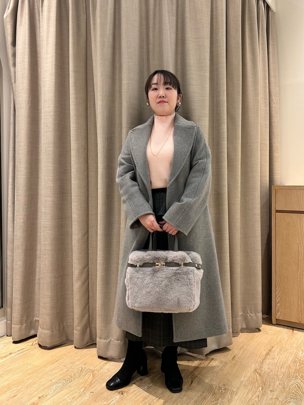 グレー系のその他アウター、ピンク系のニット/セーター、ブラック系のスカートを着用したレディースの冬コーディネートの10枚目の写真